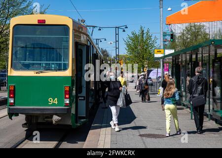 In Helsinki, Finnland, steigen Menschen mit Gesichtsbesuche aus der älteren Straßenbahn Stockfoto