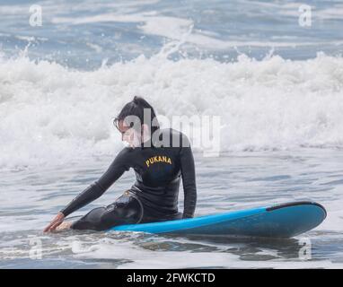 Garrettstown, Cork, Irland. Mai 2021. Eine Sufer macht eine Pause auf ihrem Board bei rauen Bedingungen in Garrettstown, Co. Cork, Irland.- Credit; David Creedon / Alamy Live News Stockfoto