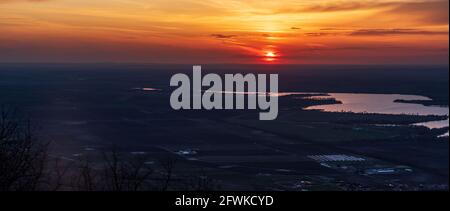 Sonnenuntergang vom Berg Devin in den Palava Bergen in Tschechien mit Nove Mlyny See, Hügeln im Hintergrund, Sonne und buntem Himmel mit Wolken Stockfoto