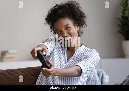 Glückliche tausendjährige afrikanische Frau spielt Online-Videospiel. Stockfoto