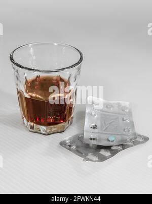 Ein Glas alkoholisches Getränk und Medikamente. Stockfoto