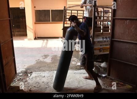 Guwahati, Indien. Mai 2021. Die Arbeiter tragen am 23. Mai 2021 eine leere Sauerstoffflasche zum Befüllen an einer Sauerstofftankstelle am Gauhati Medical College and Hospital in Guwahati, Indien. Städte und Städte Indiens hatten Schwierigkeiten, COVID-19-Coronavirus-Patienten unter einem schweren Sauerstoffmangel beim Atmen zu halten. Quelle: David Talukdar/ZUMA Wire/Alamy Live News Stockfoto