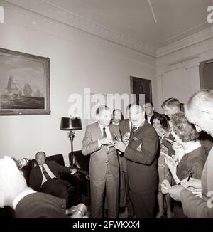 Der Schauspieler und Komiker Bob Hope zeigt seinen Komödianten Milton Berle, seine Goldmedaille des Kongresses, die ihm Anfang des Tages von Präsident John F. Kennedy in Anerkennung seiner Verdienste als Entertainer für das Land während des Zweiten Weltkriegs überreicht wurde Reporter beobachten, darunter die Korrespondentin des Weißen Hauses für United Press International (UPI), Helen Thomas (hinter Hope stehend) und der politische Reporter der New York Times in Washington, Tom Wicker (rechts von Frau Thomas). Lobby im Westflügel, weißes Haus, Washington, D.C. Stockfoto