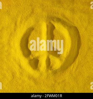 Friedenszeichen in den gelben Sand gezeichnet. Quadratisches Layout. Abstraktes Konzept. Flach liegend. Stockfoto