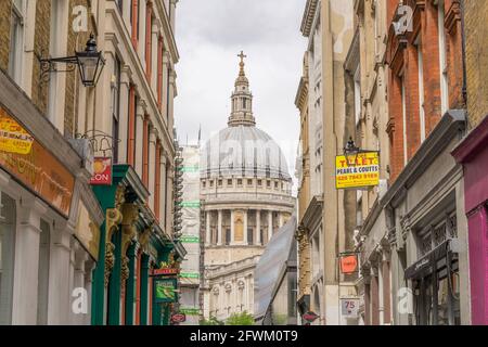 Die St. Pauls Cathedral liegt zwischen einer kleinen Gasse mit Geschäften. London Stockfoto
