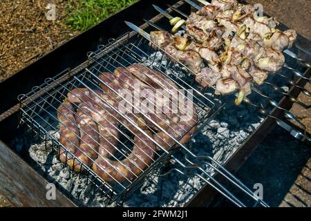 Gegrillte Fleischwürste auf dem Grill. Prozess des Kochens von Fleisch im Grill. Grill. Nahaufnahme. Selektiver Fokus. Stockfoto