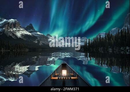 Kanufahren mit Aurora Borealis über die Bergkette im Maligne Lake im Jasper Nationalpark, Kanada. Konzept der bildenden Kunst Stockfoto