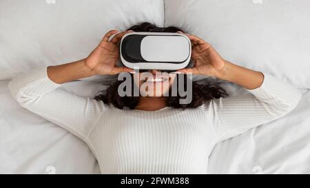 Afroamerikanische Frau Trägt Virtual Reality Brille Im Bett Stockfoto