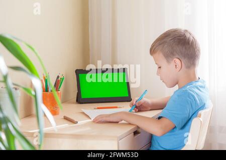 Smart Schule Junge Zeichnung Bild, Tablet mit grünem Bildschirm bleiben auf dem Schreibtisch. Konzept für Bildung und Fernunterricht. Stockfoto