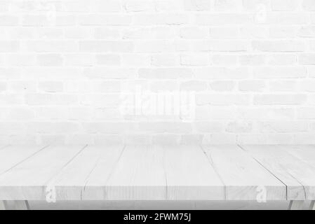 Leerer weißer Holzschreibtisch und Backsteinmauer im Hintergrund Stockfoto