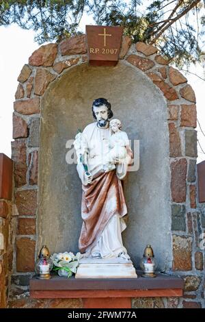 Schrein am Straßenrand mit St. Joseph Figur im Inneren, Swiatniki Gorne, Polen. Stockfoto