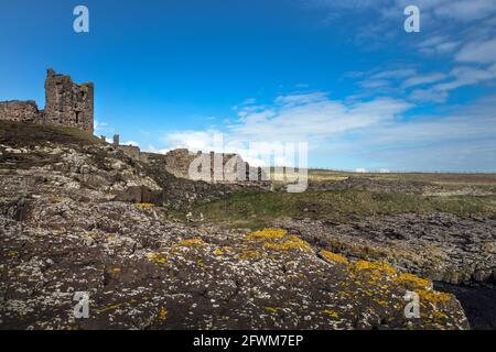 Von der St. Margarets Bay Northumberland aus kann man die Burg von Dunstanburgh sehen Stockfoto