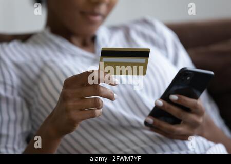 Nahaufnahme der tausendjährigen afrikanischen Frau beim Einkaufen in mobilen Anwendungen. Stockfoto