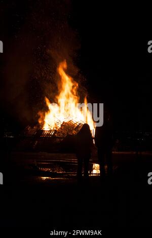 Silhouette von Mann und Frau, die ein Lagerfeuer beobachten. Stockfoto