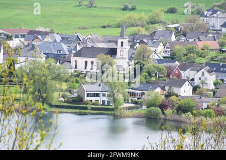 Schalkenmehrener Maar mit dem Dorf im Frühjahr Stockfoto