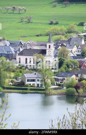 Schalkenmehrener Maar mit dem Dorf im Frühjahr Stockfoto
