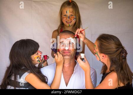 Kinder Mädchen malt Gesicht seines Vaters. Frohe Familie. Stockfoto