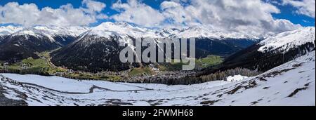 Panoramabild von der schatzalp oberhalb von davos. Blick auf die Stadt Davos mit den verschneiten Bergen im Frühling Stockfoto