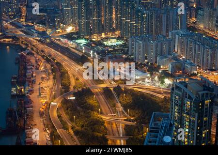 Erhöhter Blick auf die Nachtsicht dicht gepackter Wohngebäude und Autobahnen in Hong Kong, VR China Stockfoto