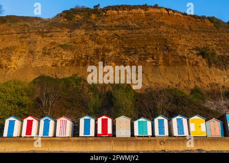 England, Isle of Wight, Shanklin Beach, Bunte Strandhütten und Klippen Stockfoto