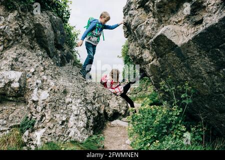 Kinder klettern auf Felsen im Corfe Castle und erkunden die Landschaft Stockfoto