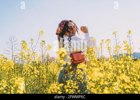 Schöne Frau mit Kopftuch, die an einem sonnigen Frühling unterwegs ist Tag für Tag Stockfoto