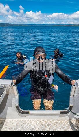 diver klettert nach einem erfolgreichen Tauchgang wieder in den Dingy Raja Ampat Stockfoto