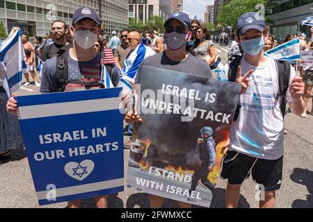 NEW YORK, NY - 23. MAI: Pro-israelische Anhänger halten während einer Kundgebung zur Unterstützung Israels und gegen Antisemitismus am 23. Mai 2021 in New York City Zeichen mit den Aufschrift "Israel in unseren Herzen" und "Israel ist angegriffen, ich stehe mit Israel" in der Innenstadt. Jüdische und pro-israelische Demonstranten versammelten sich am Standort des World Trade Centers, unter israelischer und amerikanischer Flagge, in Solidarität mit Israel nach dem jüngsten Krieg mit der Hamas in Gaza, und als Protest gegen den zunehmenden Antisemitismus und schwere antijüdische Angriffe nach dem Konflikt. Kredit: Ron Adar/Alamy Live Nachrichten Stockfoto