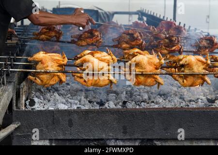 Der Straßenverkäufer röstet ganze Hühner über einer Kohlegrube auf der Insel Oahu. Stockfoto