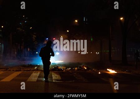 Medellin, Antioquia, Kolumbien. Mai 2021. Ein Demonstranten steht vor einem Aufstands-Panzer während der Zusammenstöße und Unruhen, die sich in Medellin, Kolumbien, entwickeln, nachdem Demonstranten und Bereitschaftspolizei (ESMAD) während einer Demonstration, die zu Zusammenstößen eskalierte, nachdem Sicherheitskameras und Handel von dem Protest betroffen waren. In Medellin, Antioquia, Kolumbien am 22, 2021. Quelle: Miyer Juana/LongVisual/ZUMA Wire/Alamy Live News Stockfoto