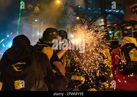 Medellin, Antioquia, Kolumbien. Mai 2021. Demonstranten zünden einen Brandwerfer an, während sich in Medellin, Kolumbien, Auseinandersetzungen und Unruhen entwickeln, nachdem Demonstranten und Bereitschaftspolizei (ESMAD) während einer Demonstration, die zu Zusammenstößen eskalierte, nachdem Sicherheitskameras und Handel von den Protesten betroffen waren. In Medellin, Antioquia, Kolumbien am 22, 2021. Quelle: Miyer Juana/LongVisual/ZUMA Wire/Alamy Live News Stockfoto