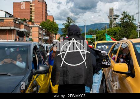 Medellin, Antioquia, Kolumbien. Mai 2021. Ein Demonstranten mit einer Flagge des Anarchy-Logos bewegt sich zwischen den Autos, während sich in Medellin, Kolumbien, Zusammenstöße und Unruhen entwickeln, nachdem Demonstranten und die Bereitschaftspolizei (ESMAD) während einer Demonstration, die zu Zusammenstößen eskalierte, nachdem Sicherheitskameras und Handel von dem Protest betroffen waren. In Medellin, Antioquia, Kolumbien am 22, 2021. Quelle: Miyer Juana/LongVisual/ZUMA Wire/Alamy Live News Stockfoto