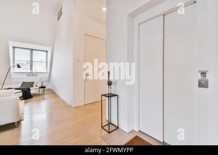 Innenarchitektur der modernen Dachgeschoss-Wohnung mit weißen Wänden und Parkettboden in minimalistischem Stil eingerichtet Stockfoto