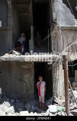 Gaza, Gaza. Mai 2021. Am sonntag, dem 23. Mai 2021, kommen Palästinenser in Beit Hanun im nördlichen Gazastreifen an ihren zerstörten Häusern vorbei, die durch israelische Angriffe zerstört wurden. Nach einem verheerenden 11-tägigen Konflikt mit Israel, bei dem mehr als 240 Menschen getötet und Tausende in der verarmten palästinensischen Enklave obdachlos gemacht wurden, versuchten die Bewohner des Gazastreifens ihr Leben zurückzugeben. Foto von Ismael Mohamad/UPI. Kredit: UPI/Alamy Live Nachrichten Stockfoto