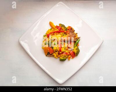 Vegane Austernpaella mit Zwiebeln, rotem Paprika, Tomaten, Broccoli und Erbsen Stockfoto