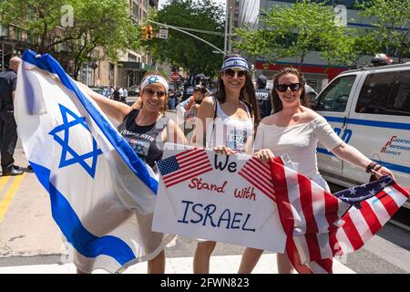 New York, Usa. Mai 2021. Pro-israelische Anhänger halten ein Plakat, auf dem steht, dass wir bei der Demonstration mit Israel sowie israelischen und US-amerikanischen Flaggen stehen. Jüdische und pro-israelische Demonstranten versammelten sich am Standort des World Trade Centers, Die israelische und amerikanische Flagge schwenken, um sich nach dem jüngsten Krieg mit der Hamas in Gaza solidarisch mit Israel zu zeigen und gegen den zunehmenden Antisemitismus und die schweren antijüdischen Angriffe nach dem Konflikt zu protestieren. (Foto von Ron Adar/SOPA Images/Sipa USA) Quelle: SIPA USA/Alamy Live News Stockfoto