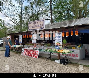 Ein Paar, das vor dem Abita Farmers Market steht, mit Obst, Gemüse, Gelees, Marmeladen und Eiern, die in Louisiana zum Verkauf stehen. Stockfoto