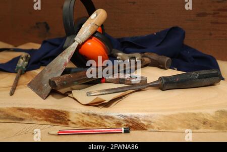 Eine Anordnung von traditionellen manuellen Gebäudeeinbau- oder Handelsinstrumenten. Heimwerkerausrüstung auf geschliffener roher Holzrunde. Stockfoto