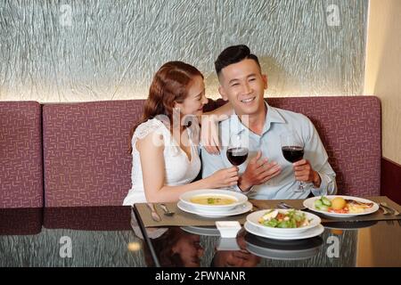 Junges Paar, das guten Wein genießt und sich in einem schicken Restaurant unterhält Stockfoto