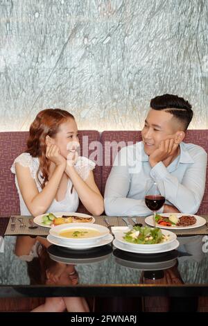 Junger Freund und Freundin in der Liebe Blick auf einander Beim Abendessen im Restaurant Stockfoto