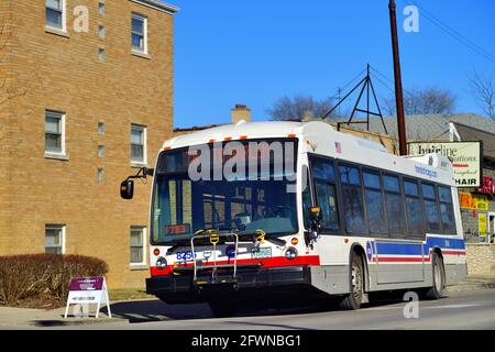 Chicago, Illinois, USA. Der CTA-Bus fährt von einer Bushaltestelle ab, nachdem er Passagiere auf der Nordwestseite der Stadt abgeholt und entladen hat. Stockfoto