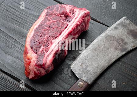 Frisches, riesiges und appetitliches, trocken gealtertes Club Steak-Set auf schwarzem Holztisch im Hintergrund Stockfoto