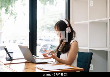 Die Seitenansicht der Geschäftsfrau kommuniziert per Videokonferenz. Asiatische Frau mit Laptop-Computer für Gruppentreffen Stockfoto