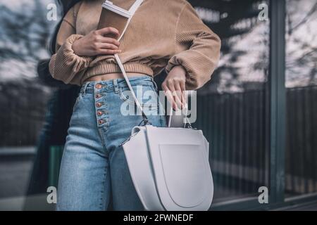 Nahaufnahme einer Frau, die ihr ein Smartphone zulegt Tasche Stockfoto