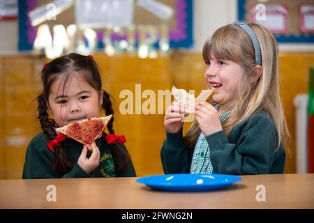 NUR FÜR REDAKTIONELLE ZWECKE (von links nach rechts) Nell und Tae, Schüler der 1. Klasse der Hollydale Primary School in London, besuchen ihren Frühstücksclub, während Greggs seinen jährlichen Breakfast Club Appeal startet, der Kunden dazu ermutigt, 25p bei jedem Kauf zu spenden, um einem bedürftigen Kind ein nahrhaftes Frühstück zu bieten. Ausgabedatum: Montag, 24. Mai 2021. Stockfoto