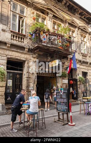 Nicht identifizierte Menschen hängen am Eingang des Szimppla-Gartens Ruin Club in Budapest Stockfoto