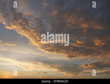 Goldene Wolke und blauer Himmel in magischer Stunde bei Sonnenuntergang begann sich der Horizont orange zu drehen, mit violetten Wolken in der Nacht, dramatischer Wolkenlandschaft Stockfoto