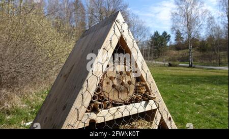 Insektenhotel. Holzstruktur mit natürlichem Material gefüllt bereit, Insekten während des Frühlings willkommen. Stockfoto