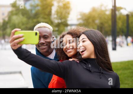 Multiethnische Freunde im Freien nehmen ein Selfie auf dem Smartphone. Diverse Gruppe Menschen Afro american Asian verbringen Zeit zusammen multirassischen männlichen weiblichen st Stockfoto