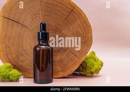 Flasche mit Pipette, Hautpflegeserum oder Öl, auf Holzständer. Stockfoto